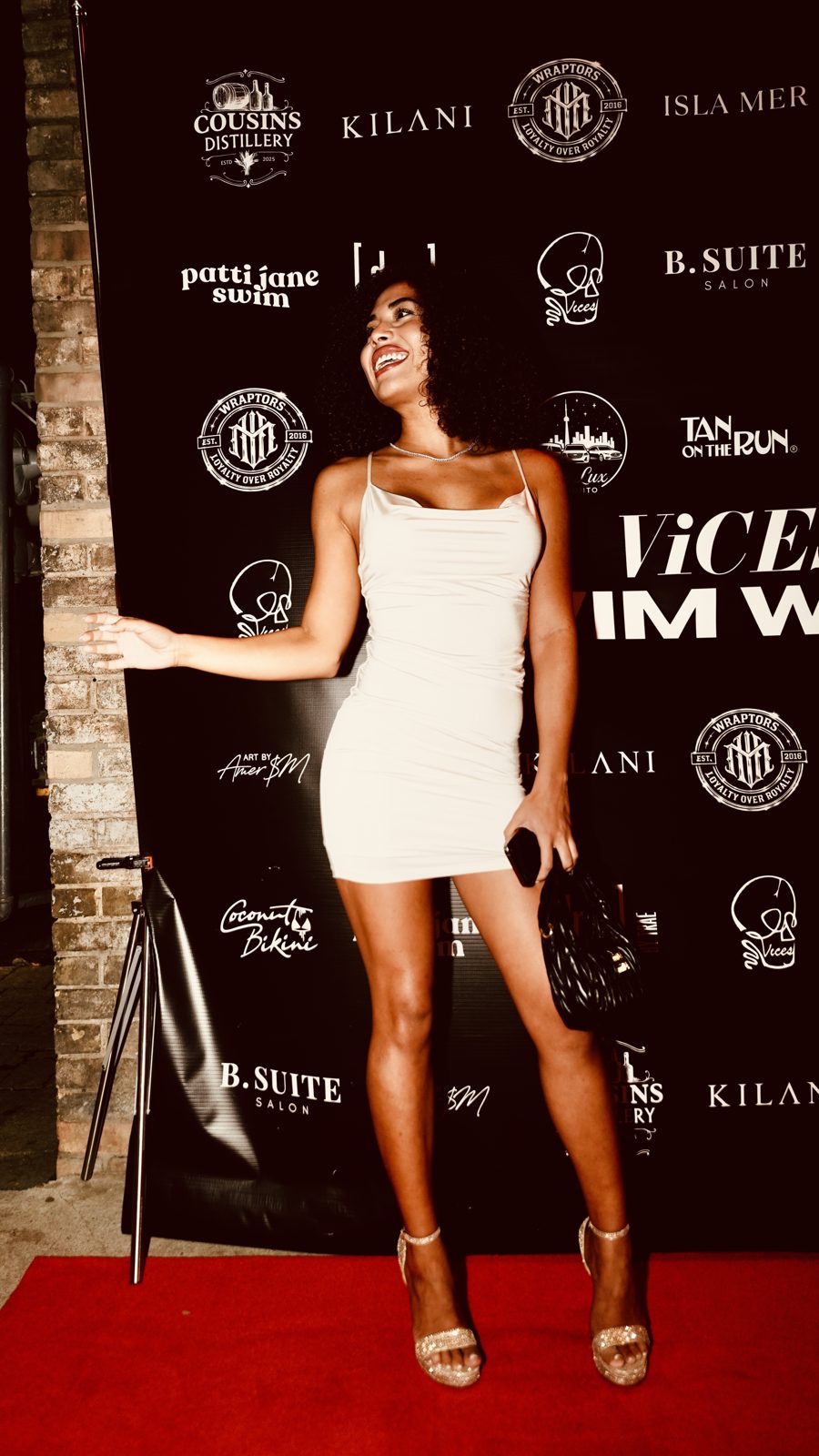 Guest posing on the ViCES Swim Week red carpet