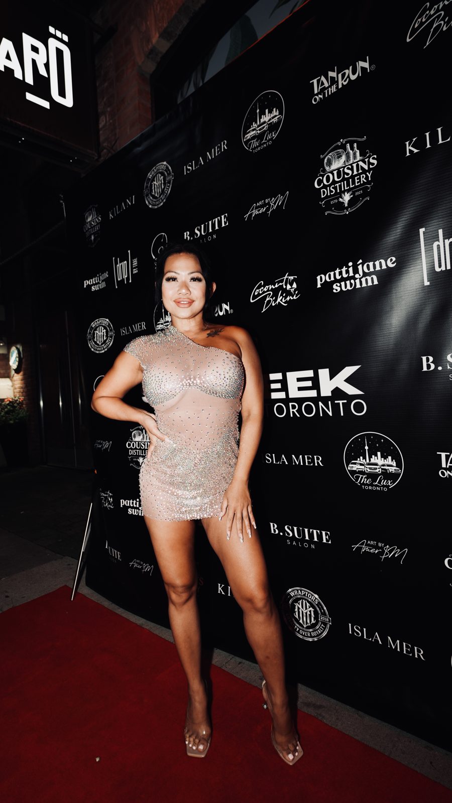 Evening look photographed on the branded press wall